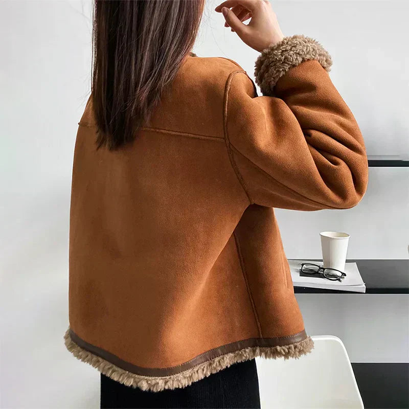 Giacca invernale marrone con bordo in pelliccia sintetica, indossata da una donna di spalle. Moda autunnale, abbigliamento caldo e casual.