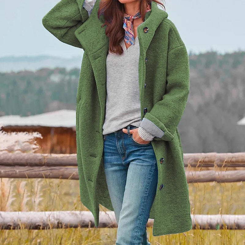 Donna con cappotto verde, jeans e sciarpa colorata in campagna. Moda autunnale, abbigliamento casual, stile outdoor.
