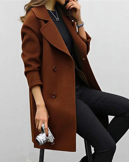 Donna con cappotto marrone elegante, seduta, tiene una fotocamera vintage. Moda autunnale, stile casual chic, abbigliamento femminile trendy.