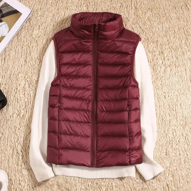 Gilet imbottito rosso bordeaux su maglione bianco, moda autunno inverno, abbigliamento casual caldo, stile elegante su sfondo beige.