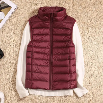 Gilet imbottito rosso bordeaux su maglione bianco, moda autunno inverno, abbigliamento casual caldo, stile elegante su sfondo beige.
