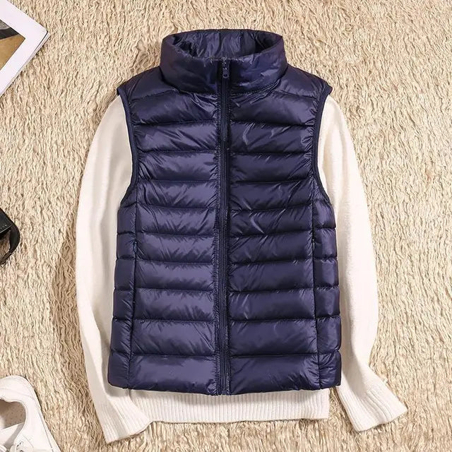 Gilet imbottito blu su maglione bianco, moda autunno inverno, abbigliamento casual, tessuto trapuntato, stile moderno, su sfondo beige.