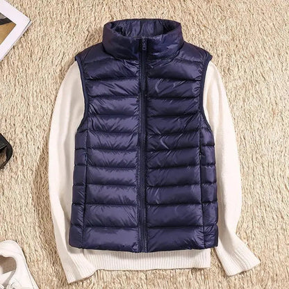 Gilet imbottito blu su maglione bianco, moda autunno inverno, abbigliamento casual, tessuto trapuntato, stile moderno, su sfondo beige.