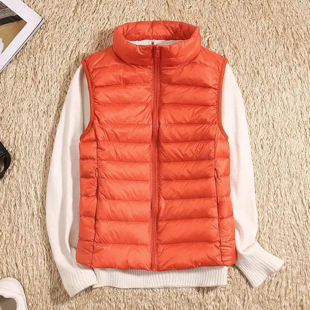 Gilet arancione imbottito su maglione bianco, moda autunno inverno, abbigliamento casual caldo, stile moderno, tessuto trapuntato.
