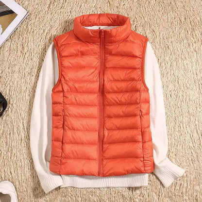 Gilet arancione imbottito su maglione bianco, moda autunno inverno, abbigliamento casual caldo, stile moderno, tessuto trapuntato.