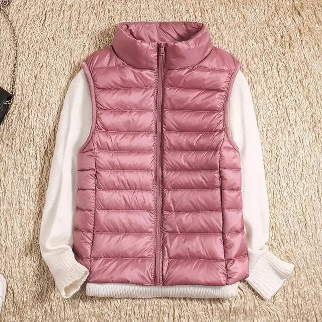 Gilet imbottito rosa su maglione bianco, moda autunno inverno, abbigliamento casual donna, tessuto trapuntato, stile moderno e caldo.