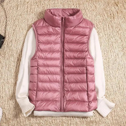 Gilet imbottito rosa su maglione bianco, moda autunno inverno, abbigliamento casual donna, tessuto trapuntato, stile moderno e caldo.