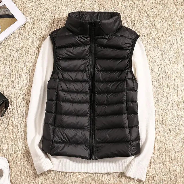 Gilet imbottito nero su maglione bianco, moda autunnale, abbigliamento casual, tessuto trapuntato, stile moderno, outfit caldo e confortevole.