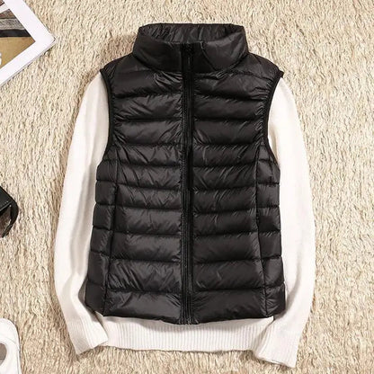 Gilet imbottito nero su maglione bianco, moda autunnale, abbigliamento casual, tessuto trapuntato, stile moderno, outfit caldo e confortevole.