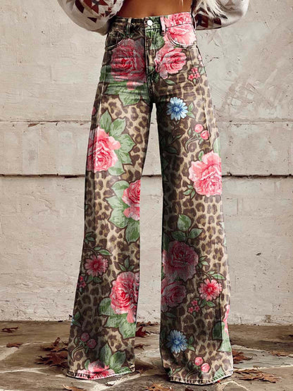 Jeans a zampa con stampa floreale e leopardata, sfondo beige, dettagli di rose rosa e fiori blu, moda vintage, stile boho-chic.