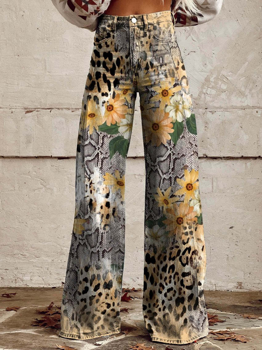 Jeans a zampa con stampa animalier e floreale, motivo pitonato e leopardato, decorati con fiori gialli e foglie verdi, moda autunnale.