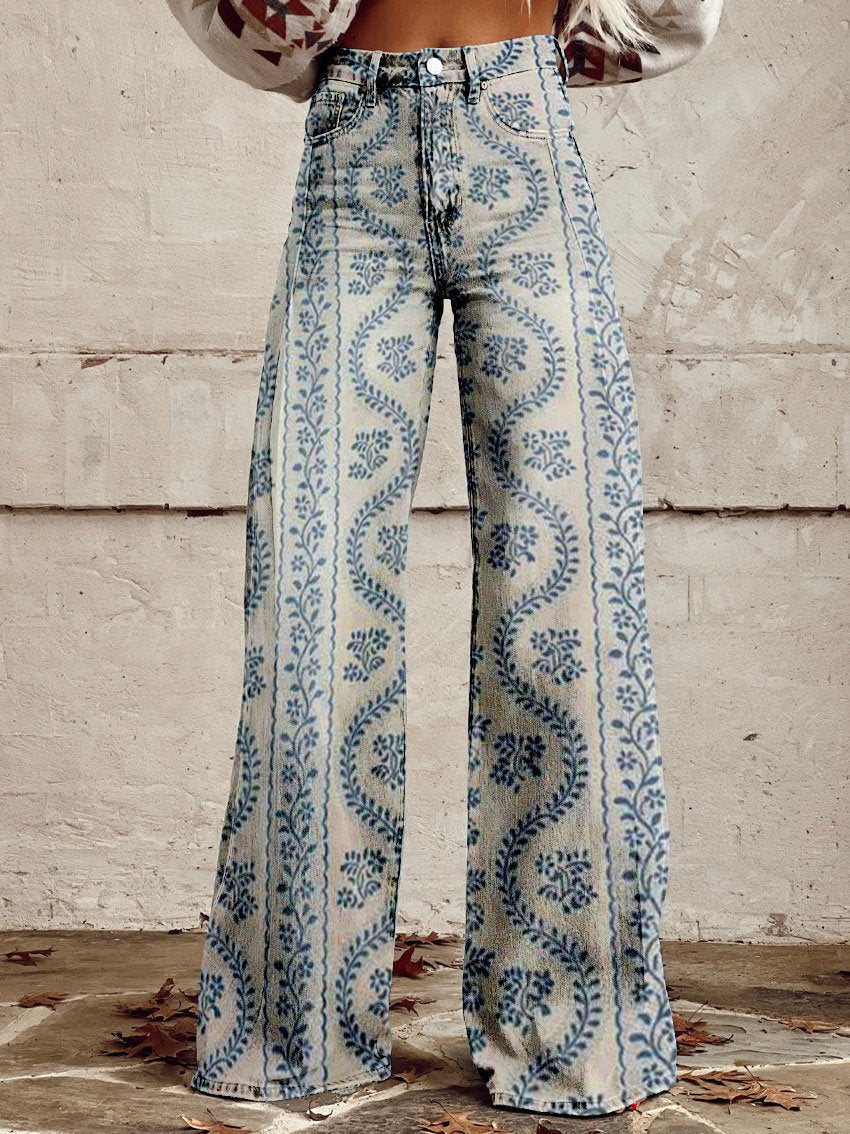 Jeans a zampa d'elefante con motivo floreale blu su sfondo bianco, indossati da una persona. Stile vintage, moda autunnale, tendenza anni '70.