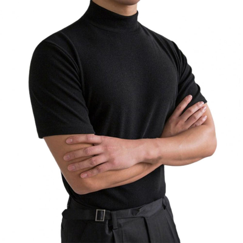 Uomo in maglia nera a collo alto, maniche corte, braccia incrociate. Moda maschile elegante, abbigliamento casual chic, stile minimalista.