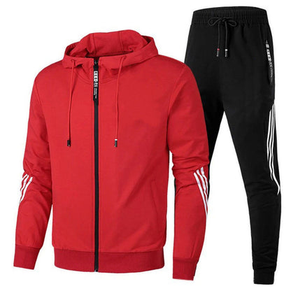 Tuta sportiva uomo: felpa rossa con cappuccio e zip, pantaloni neri con strisce bianche. Abbigliamento casual, moda fitness, stile moderno.
