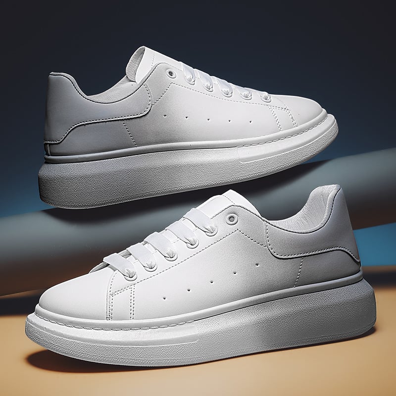 Scarpe da ginnastica bianche su sfondo neutro, design minimalista, suola spessa. Sneakers moda uomo, calzature casual eleganti e moderne.