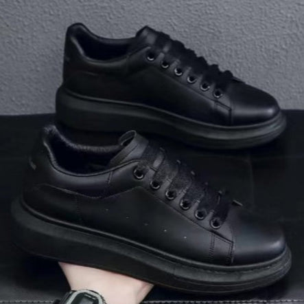 Scarpe da ginnastica nere su sfondo grigio, design moderno e minimalista, suola spessa, perfette per moda urbana e casual.