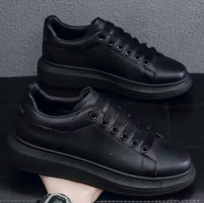 Scarpe da ginnastica nere su sfondo grigio, design moderno e minimalista, suola spessa, perfette per moda urbana e casual.