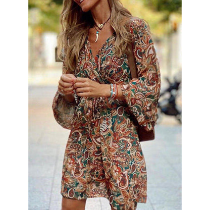 Donna con abito boho a fantasia floreale, maniche lunghe, in strada. Stile casual chic, moda autunnale, accessori eleganti.