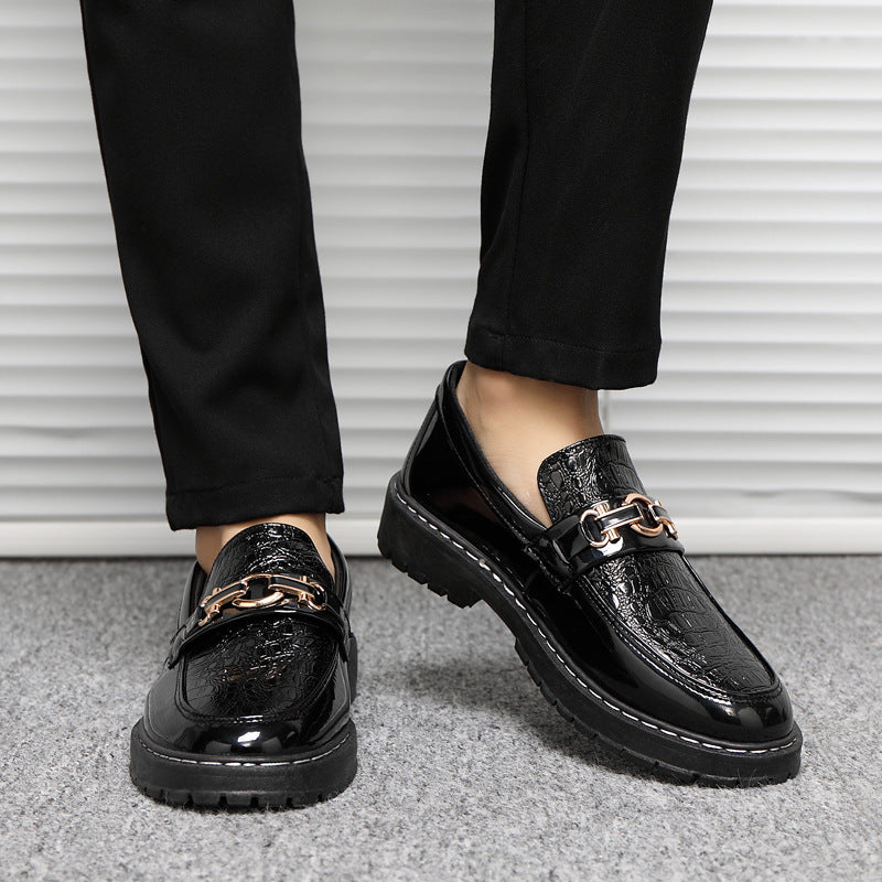 Scarpe mocassini uomo in pelle nera lucida con dettaglio catena dorata, indossate con pantaloni neri. Eleganti e moderne, ideali per look formali.