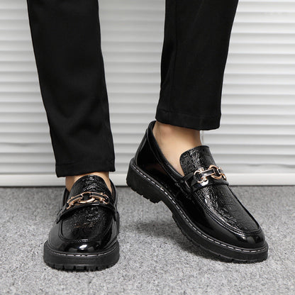 Scarpe mocassini uomo in pelle nera lucida con dettaglio catena dorata, indossate con pantaloni neri. Eleganti e moderne, ideali per look formali.
