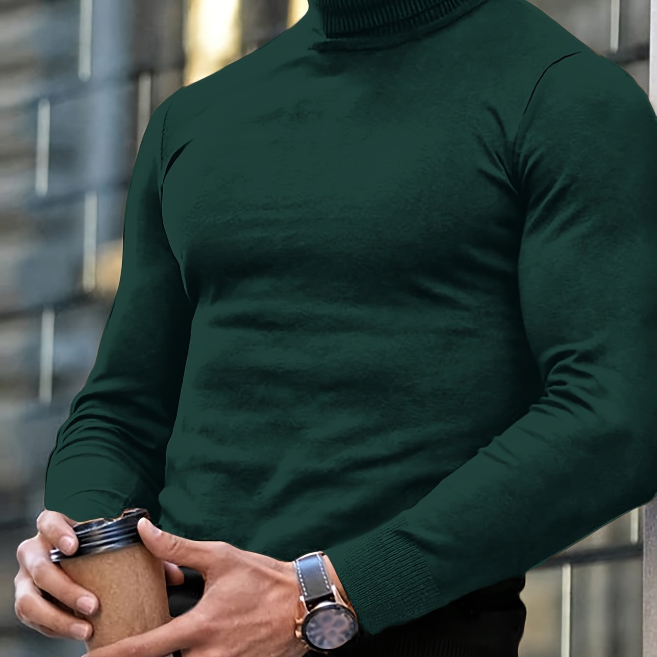 Uomo in maglione verde scuro con orologio elegante, tiene una tazza da caffè. Moda maschile autunnale, stile urbano, accessori di classe.