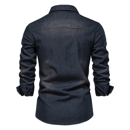Men's solid-color denim shirt with textured fabric, chest pockets, and long sleeves.
