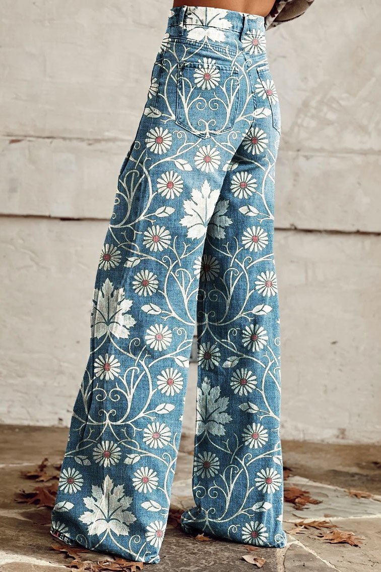 Jeans a zampa d'elefante in denim con motivo floreale bianco e foglie, stile vintage, su sfondo neutro. Moda autunnale, pantaloni decorati.