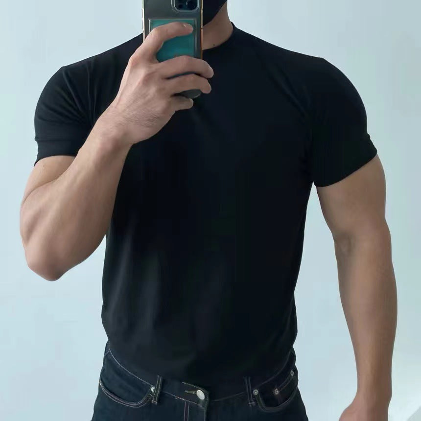 Uomo in t-shirt nera aderente, jeans scuri, scatta selfie con smartphone. Moda casual maschile, abbigliamento estivo, stile minimalista.