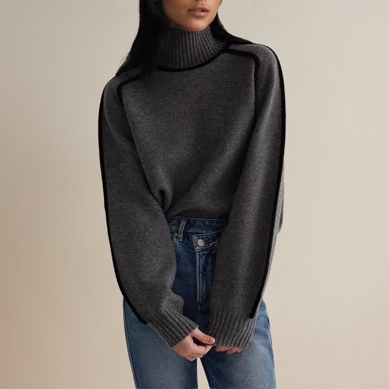 Maglione grigio a collo alto indossato da una donna, abbinato a jeans blu. Moda autunnale, abbigliamento casual elegante, stile minimalista.