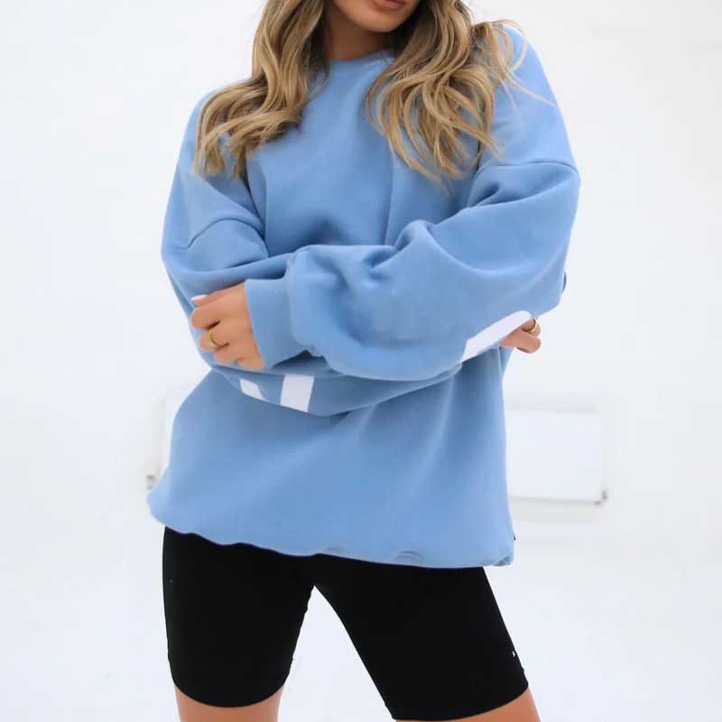 Donna con felpa oversize azzurra e pantaloncini neri, moda casual, abbigliamento sportivo, stile urbano, tendenze moda 2023.