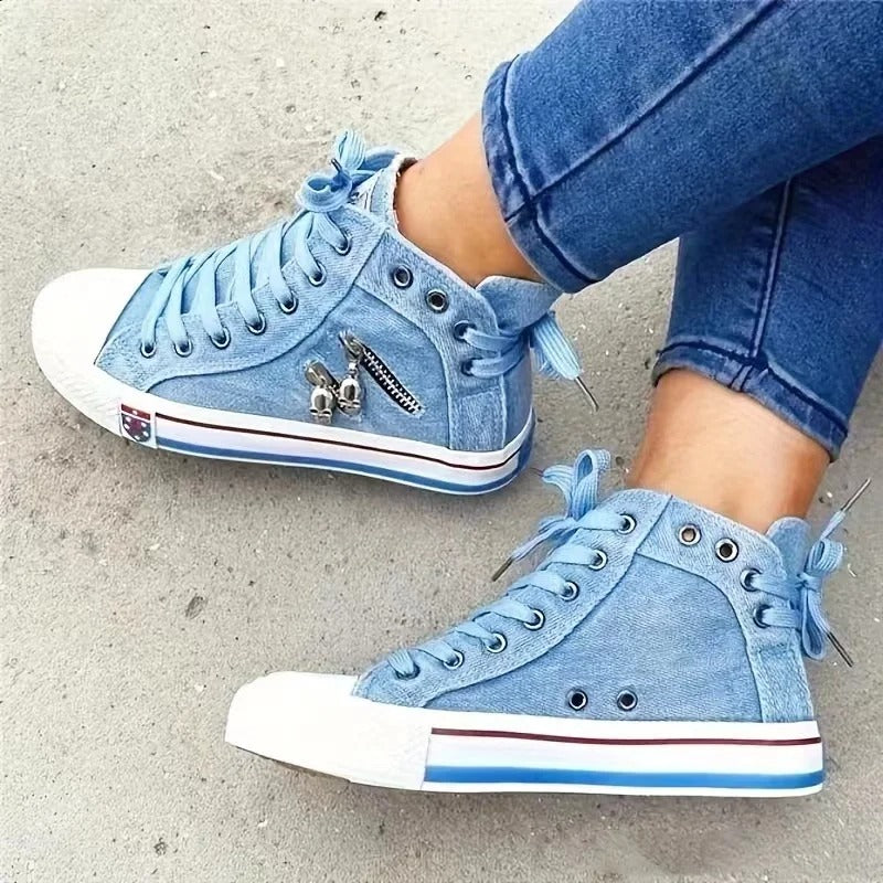 Scarpe da ginnastica alte in denim blu con lacci, dettagli in metallo e suola bianca. Moda casual, calzature trendy, stile urbano.