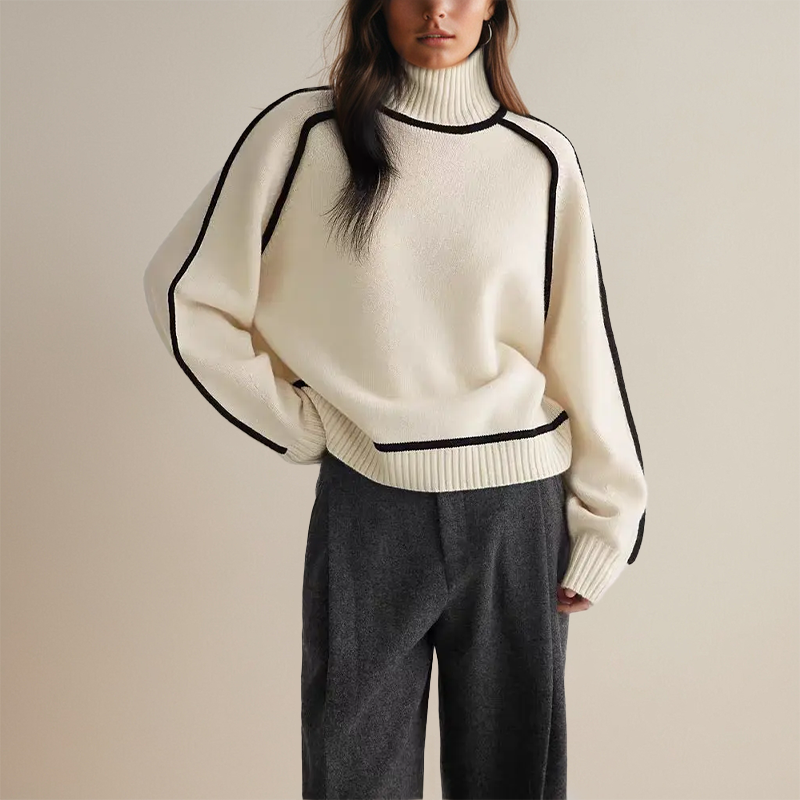 Maglione bianco a collo alto con dettagli neri, indossato con pantaloni grigi. Moda autunnale elegante, abbigliamento casual chic donna.