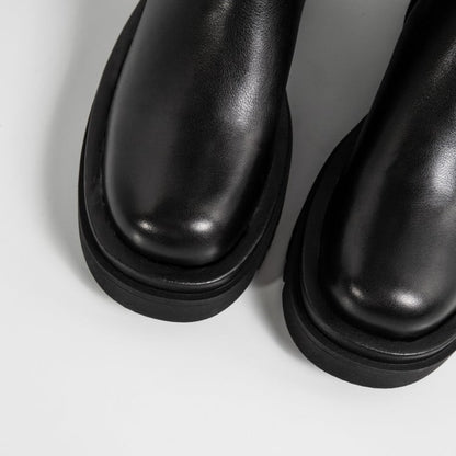 Stivali neri in pelle lucida su sfondo bianco, moda autunno inverno, calzature eleganti, tendenza scarpe donna, design minimalista.