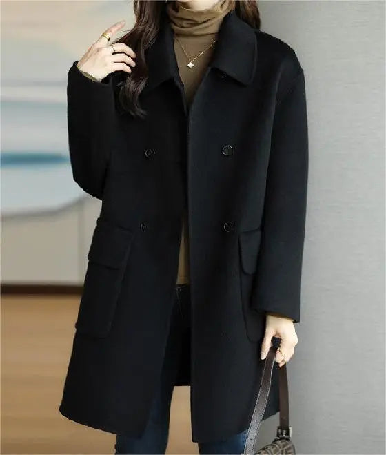 Cappotto nero elegante da donna, doppio petto, con tasche, indossato su maglione marrone. Moda autunnale, abbigliamento femminile chic.