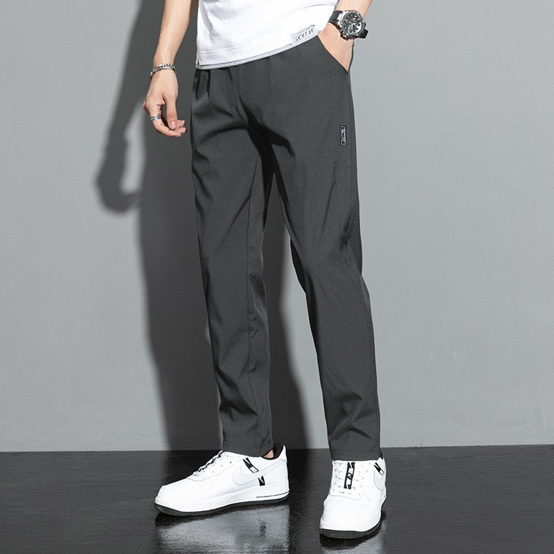 Pantaloni uomo eleganti grigi, abbinati a scarpe da ginnastica bianche, moda casual, stile moderno, perfetti per look quotidiano e urbano.