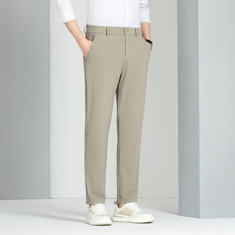 Pantaloni chino beige da uomo, eleganti e moderni, abbinati a camicia bianca e scarpe sportive bianche. Moda maschile casual chic.