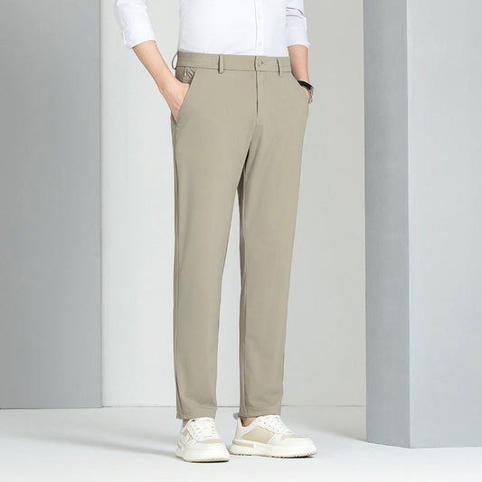 Pantaloni chino beige da uomo, eleganti e moderni, abbinati a camicia bianca e scarpe sportive bianche. Moda maschile casual chic.