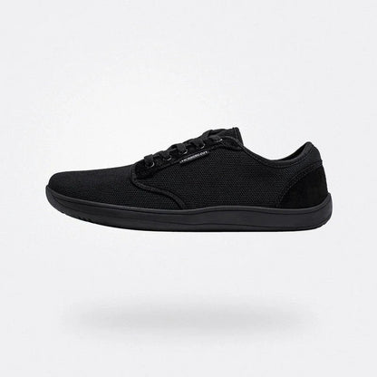 Scarpa sportiva nera minimalista su sfondo bianco, design leggero e moderno, perfetta per attività sportive e casual. Scarpe da ginnastica eleganti.