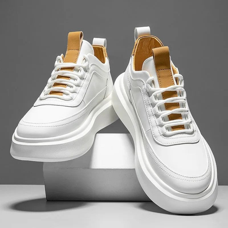 Scarpe da ginnastica bianche moderne su sfondo grigio, design minimalista con dettagli marroni, suola spessa. Scarpe sportive eleganti e alla moda.