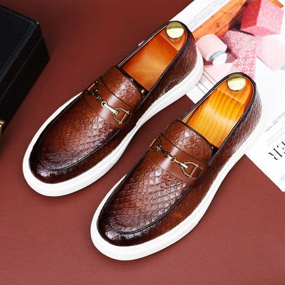 Scarpe mocassini uomo in pelle marrone con motivo a serpente, suola bianca, dettagli metallici dorati. Eleganti e alla moda, ideali per look casual-chic.