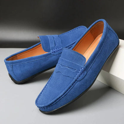 Mocassini uomo in pelle scamosciata blu, suola nera, design elegante e moderno, perfetti per look casual e formali. Scarpe moda maschile.