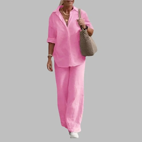 Donna in abito di lino rosa, camicia e pantaloni, con borsa a tracolla beige. Moda estiva casual, abbigliamento femminile elegante.