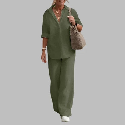 Donna con abbigliamento casual verde oliva, camicia e pantaloni larghi, borsa intrecciata beige, scarpe bianche. Moda donna, stile estivo elegante.