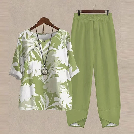 Completo estivo donna: blusa verde con stampa floreale bianca e pantaloni coordinati. Moda casual, abbigliamento leggero, stile fresco.