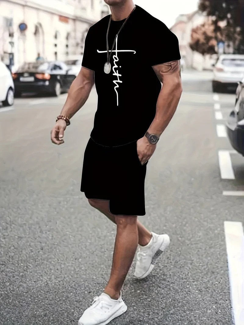 Uomo in abbigliamento casual nero con scritta "faith", cammina su strada cittadina. Indossa scarpe bianche, orologio e collana. Moda urbana estiva.