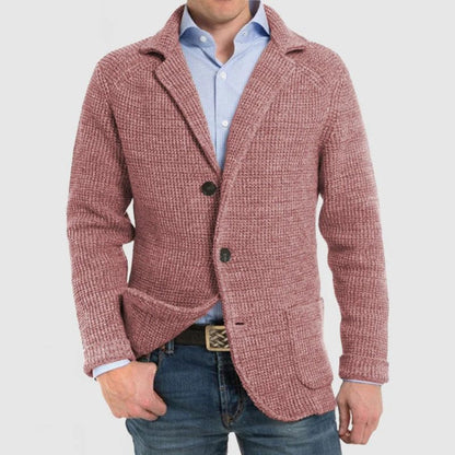 Giacca uomo in maglia rosa, stile casual, con bottoni e tasche frontali, indossata su camicia azzurra e jeans. Moda maschile elegante.