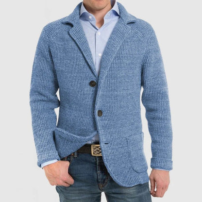 Uomo con giacca in maglia blu, camicia azzurra e jeans. Moda maschile casual elegante, abbigliamento autunnale, stile moderno.