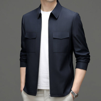 Giacca uomo blu scuro elegante, con zip e tasche frontali, indossata su maglietta bianca. Moda maschile, abbigliamento casual chic.
