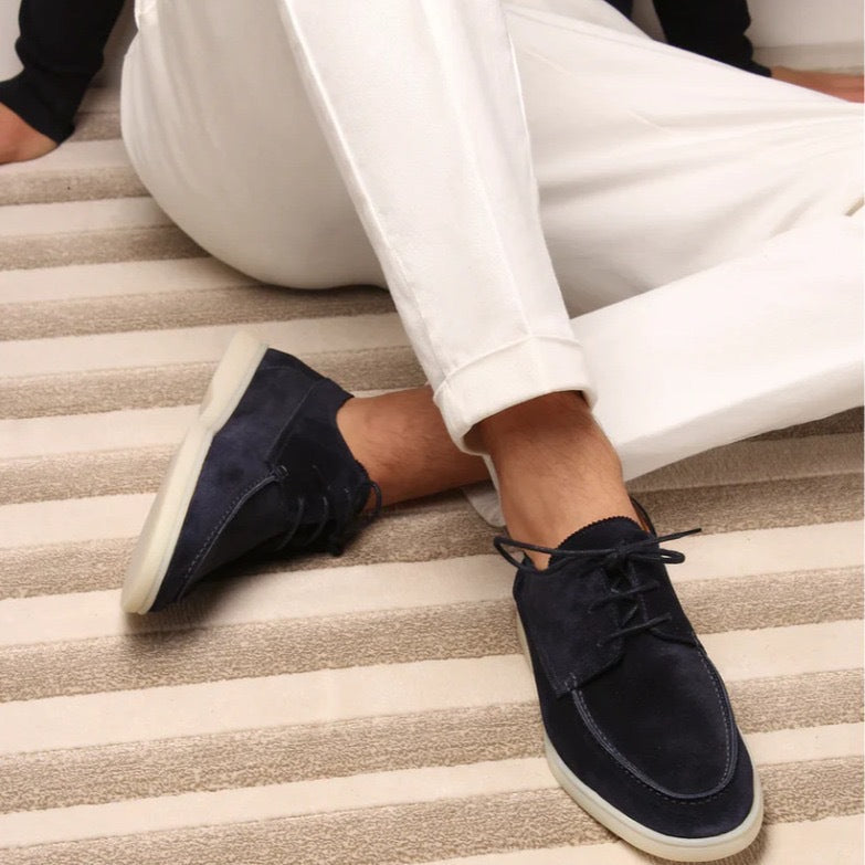 Men’s suede-style boat shoes with laces, moccasin stitching, and a thick contrasting sole.