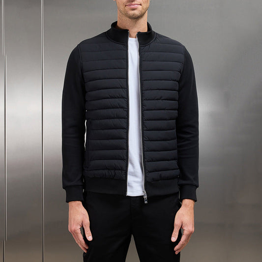 Giacca uomo nera trapuntata, stile casual, con zip frontale, indossata su maglietta bianca. Moda maschile autunno-inverno, abbigliamento moderno.